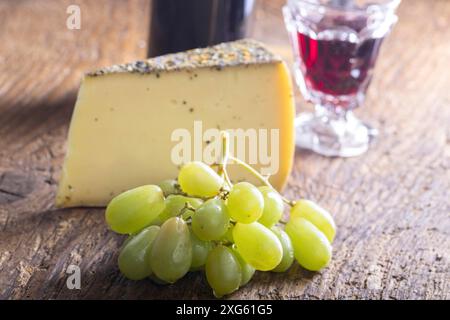 Fromage de montagne avec raisins sur bois Banque D'Images