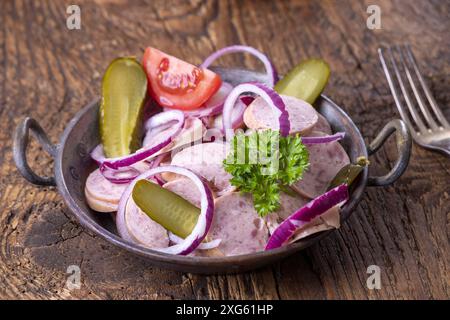 Salade de saucisses bavaroises sur bois sombre Banque D'Images