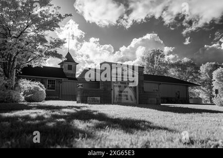 Une image en noir et blanc d'une petite église dans le sud de l'Indiana. Il y a une rivière comme une zone de ciel ouvert au-dessus du bâtiment entre les nuages. Banque D'Images