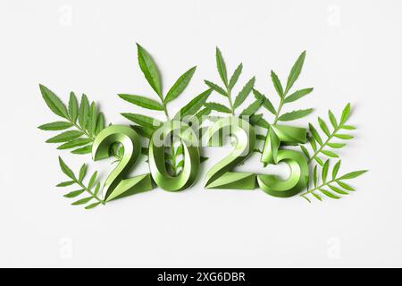 Numéros verts et feuilles vertes sur fond gris. concept d'idée du nouvel an 2025. Design simple et propre bonne année 2025 et joyeux Noël. Pose à plat Banque D'Images