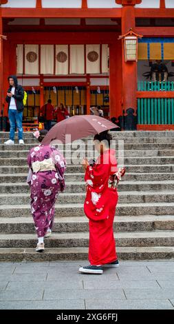 JAPON, KYOTO – avril 2024 : jeune fille vêtue de kimono au temple-sanctuaire Fushimiinari Taisha à Kyoto, Japon Banque D'Images