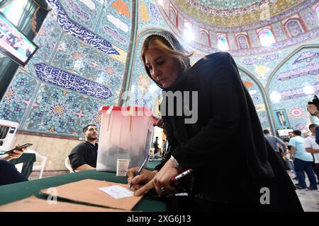 Téhéran, Iran. 5 juillet 2024. Une électrice dépose son bulletin de vote dans un bureau de vote à Téhéran, Iran, le 5 juillet 2024. Masoud Pezeshkian, ancien ministre iranien de la santé, a remporté la 14e élection présidentielle du pays, a annoncé samedi le porte-parole du siège électoral iranien Mohsen Eslami. Eslami a fait cette annonce tout en dévoilant les résultats du second tour qui s'est tenu vendredi entre le réformiste Pezeshkian et le principliste Saeed Jalili, ancien négociateur en chef de l'Iran dans les pourparlers nucléaires avec les puissances mondiales. Crédit : Shadati/Xinhua/Alamy Live News Banque D'Images