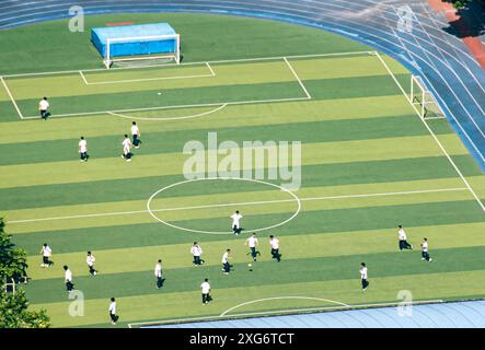 Une vue aérienne d'un terrain de football avec des joueurs qui s'entraînent un jour d'été Banque D'Images