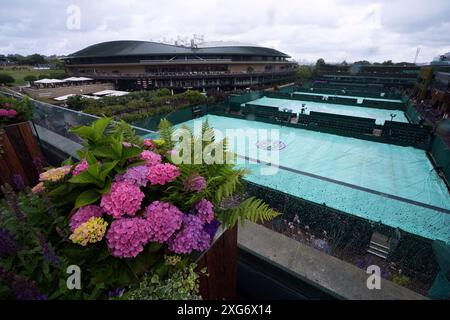 Une vue générale sur les courts extérieurs couverts alors que la pluie tombe le septième jour des Championnats de Wimbledon 2024 au All England Lawn Tennis and Croquet Club, Londres. Date de la photo : dimanche 7 juillet 2024. Banque D'Images