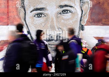 Les spectateurs passent devant une fresque de Lewis Hamilton avant la course au circuit de Silverstone, dans le Northamptonshire. Date de la photo : dimanche 7 juillet 2024. Banque D'Images