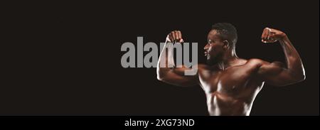 Homme musclé Flexing biceps sur fond noir Banque D'Images