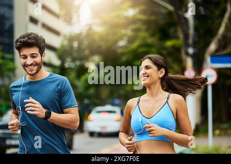 Couple, écouteurs et course en ville pour le fitness, cardio ou club avec audio ou podcast. Technologie, écoute ou formation et mobile ou personnel en ligne Banque D'Images