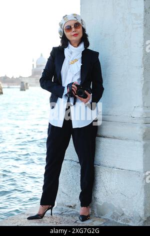 Venise, une femme glamour bien habillée se tient à Punta della Dogana devant une vue sur l'eau, Bacino di San Marco à San Giorgio Maggiore Banque D'Images