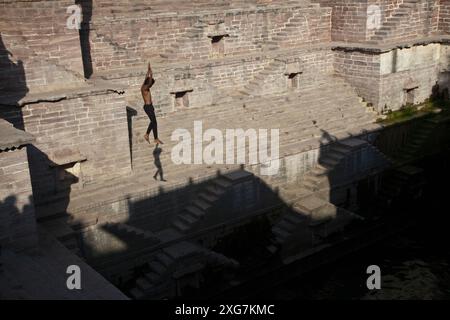 Jeune homme sautant dans le stepwell des Toorji (Toorji Ka Jhalra), Jodpur, Inde. Construit dans les années 1740 par le Consort du Maharaja Abhay Singh. Banque D'Images