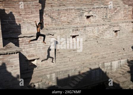 Jeune homme sautant dans le stepwell des Toorji (Toorji Ka Jhalra), Jodpur, Inde. Construit dans les années 1740 par le Consort du Maharaja Abhay Singh. Banque D'Images