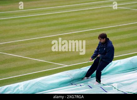 Le personnel au sol retire les couvertures le septième jour des Championnats de Wimbledon 2024 au All England Lawn Tennis and Croquet Club de Londres. Date de la photo : dimanche 7 juillet 2024. Banque D'Images