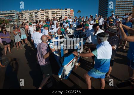 Malaga, Espagne. 07 juillet 2024. On voit des hommes pousser un « jabega » (bateau de pêche) vers la mer à la plage alors qu'ils participent à l'exposition « la Tirada del Copo » sur la plage de Los Boliches. Chaque année à Fuengirola, les habitants célèbrent une vieille tradition de pêche connue sous le nom de « la Tirada del Copo » pour mettre en valeur les compétences et le métier des marins et des pêcheurs lors de la capture de poissons dans la mer. Comme le veut la tradition, pendant la « Tirada del Copo », les marins jettent des filets dans la mer, formant un demi-cercle, tandis que d'autres tirent les filets vers la plage pour capturer tous les poissons. Banque D'Images