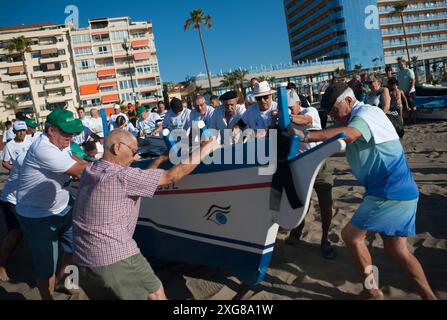 Des hommes poussent un « jabega » (bateau de pêche) sur la plage alors qu'ils participent à l'exposition « la Tirada del Copo » sur la plage de Los Boliches. Chaque année à Fuengirola, les habitants célèbrent une vieille tradition de pêche connue sous le nom de « la Tirada del Copo » pour mettre en valeur les compétences et le métier des marins et des pêcheurs lors de la capture de poissons dans la mer. Comme le veut la tradition, pendant la « Tirada del Copo », les marins jettent des filets dans la mer, formant un demi-cercle, tandis que d'autres tirent les filets vers la plage pour capturer tous les poissons. La pratique de la tirada del copo est actuellement interdite. (Photo de Jesus Merida / Banque D'Images