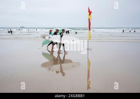 Les surfeurs apprécient les brises fraîches de l'été à Hayle Bay, le 29 juin, à Polzeath, Cornouailles, Angleterre. Banque D'Images