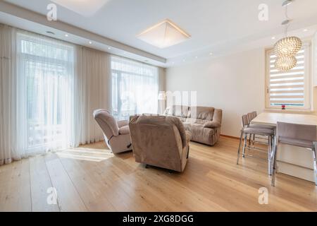 Intérieur de la salle de séjour moderne. Luxueux appartement moderne et élégant. Intérieur ouvert, canapé élégant, table Kitche. Fenêtres et rideaux. Grand angle Banque D'Images