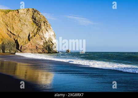 Plage californienne avec falaises, vagues et reflets. Banque D'Images