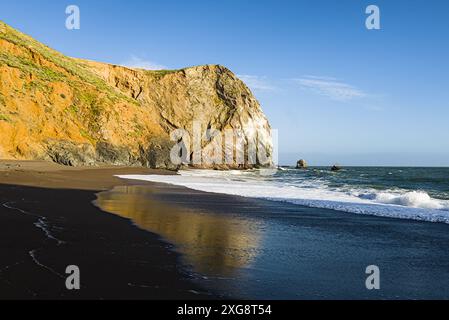 Plage californienne avec falaises, vagues et reflets. Banque D'Images