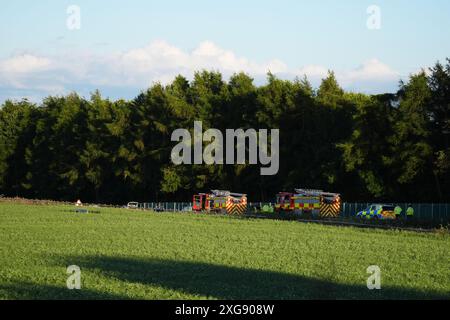 Services d'urgence par un champ par l'autoroute M9 près de Stirling par une voiture dans un champ. Un homme est mort après que la voiture est sortie de l'autoroute et a descendu un talus après une poursuite policière. Le Vauxhall Corsa blanc voyageait vers le sud sur la M9 entre les jonctions 8 et 9 quand il s'est écrasé vers 11 h 50 dimanche, a déclaré police Scotland. Date de la photo : dimanche 7 juillet 2024. Banque D'Images