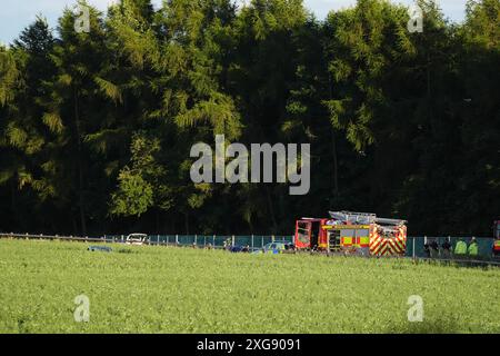 Services d'urgence par un champ par l'autoroute M9 près de Stirling par une voiture dans un champ. Un homme est mort après que la voiture est sortie de l'autoroute et a descendu un talus après une poursuite policière. Le Vauxhall Corsa blanc voyageait vers le sud sur la M9 entre les jonctions 8 et 9 quand il s'est écrasé vers 11 h 50 dimanche, a déclaré police Scotland. Date de la photo : dimanche 7 juillet 2024. Banque D'Images