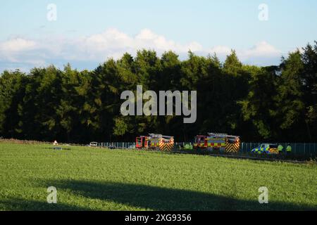 Services d'urgence par un champ par l'autoroute M9 près de Stirling par une voiture dans un champ. Un homme est mort après que la voiture est sortie de l'autoroute et a descendu un talus après une poursuite policière. Le Vauxhall Corsa blanc voyageait vers le sud sur la M9 entre les jonctions 8 et 9 quand il s'est écrasé vers 11 h 50 dimanche, a déclaré police Scotland. Date de la photo : dimanche 7 juillet 2024. Banque D'Images