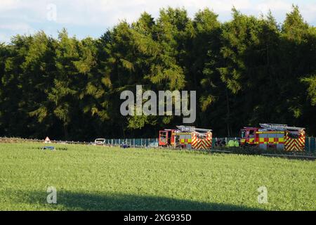 Services d'urgence par un champ par l'autoroute M9 près de Stirling par une voiture dans un champ. Un homme est mort après que la voiture est sortie de l'autoroute et a descendu un talus après une poursuite policière. Le Vauxhall Corsa blanc voyageait vers le sud sur la M9 entre les jonctions 8 et 9 quand il s'est écrasé vers 11 h 50 dimanche, a déclaré police Scotland. Date de la photo : dimanche 7 juillet 2024. Banque D'Images