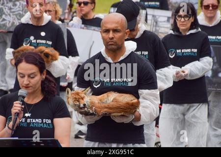 Londres, Royaume-Uni. 07 juillet 2024. Un activiste tient un renard mort pendant le mémorial We Stand for the Animals. Des militants des droits des animaux se sont réunis à Marble Arch avec des photos d'animaux exploités et de vrais animaux morts. L'événement annuel est un mémorial pour les milliards d'animaux tués, maltraités et exploités par les humains pour la nourriture, la mode, la chasse, les zoos, les expériences, et tous les autres domaines de l'activité humaine. Crédit : SOPA images Limited/Alamy Live News Banque D'Images