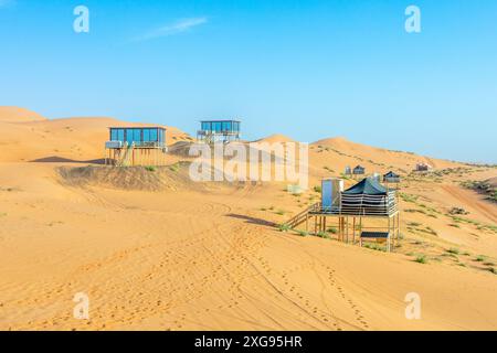 Des maisons d'hôtel du désert debout au-dessus du sable au milieu du désert de Wahiba, Oman Banque D'Images