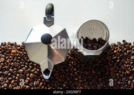 Pot de moka italien (Caffettiera ou macchinetta del caffè), cafetière italienne avec des grains de café en arrière-plan Banque D'Images