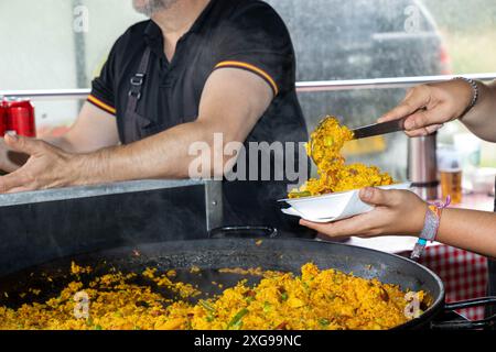 Négociant au Stockton Heath Festival 2024 vendant de la paella à partir de casseroles géantes Banque D'Images