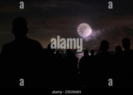 Les Marines et marins américains affectés à la 15th Marine Expeditionary Unit et le navire d'assaut amphibie USS Boxer (LHD 4) regardent des feux d'artifice au-dessus de la baie de San Diego lors d'une célébration du 4 juillet à bord du Boxer dans l'océan Pacifique le 4 juillet 2024. Des éléments de la 15e MEU sont actuellement embarqués à bord du Boxer Amphibious Ready Group menant des opérations de routine dans la 3e flotte américaine. (Photo du corps des Marines des États-Unis par le caporal Amelia Kang) Banque D'Images