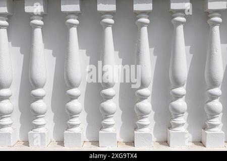 Les piliers blancs font partie d'une façade de bâtiment. Piliers décoratifs en bois dans une rangée Banque D'Images