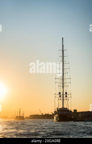 Bateau à voile de luxe amarré au port de Venise, en Italie, avec d'autres paquebots de croisière et la ligne d'horizon vénitienne sur le canal de Giudecca le jour d'été Banque D'Images