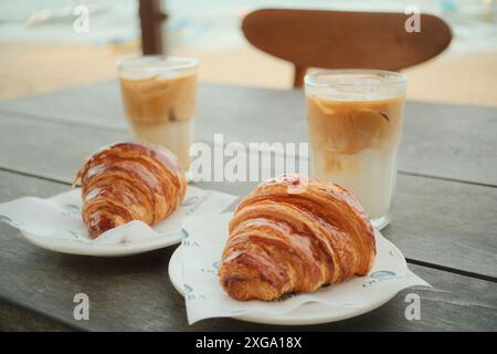 Dégustez un croissant et un latte de café glacé près de la plage Banque D'Images