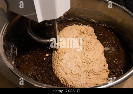 Robot de cuisine pour pétrir la pâte à pain. La pâte noire et blanche est prête à remuer. Production artisanale de pain Banque D'Images