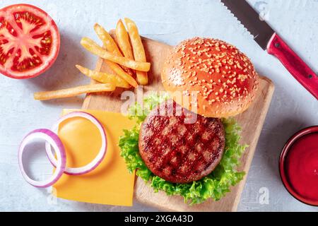 Ingrédients de hamburger, préparation à plat avec frites et sauce barbecue. Hamburger et pommes de terre, tiré par le haut Banque D'Images