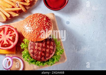 Ingrédients de Burger, tiré du dessus avec un endroit pour le texte. Steak de bœuf hamburger et frites, avec laitue, tomate et oignon Banque D'Images