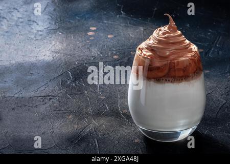 Café froid Dalgona.Une boisson coréenne avec de la crème sur fond noir et un espace de copie Banque D'Images