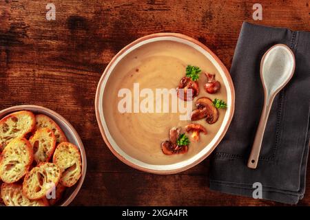 Soupe à la crème de champignons avec pain grillé, sur fond de bois rustique foncé Banque D'Images