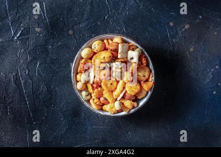 Craquelins de riz japonais dans un bol sur fond d'ardoise noire, photo en hauteur Banque D'Images