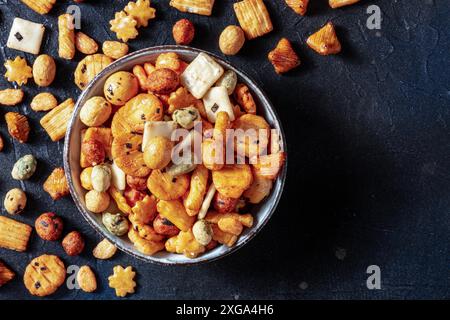 Papillotes de riz japonaises dans un bol sur fond d'ardoise noire, plan d'eau à plat au-dessus avec espace de copie Banque D'Images