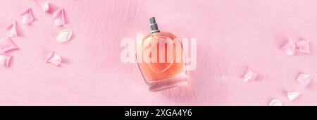 Panorama de parfum de rose avec pétales de fleur frais, photo de dessus sur fond rose, une bannière panoramique minimaliste pour un produit de parfumerie de luxe Banque D'Images