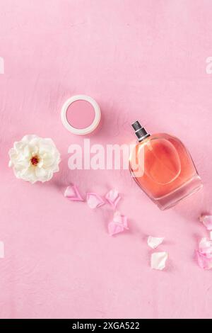 Bannière cosmétique avec parfum de rose et maquillage, prise d'en haut sur fond rose avec espace de copie Banque D'Images