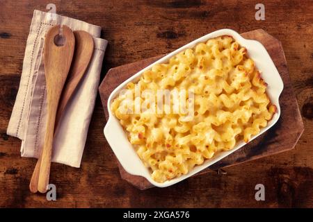 Macaroni et pâtes au fromage dans une cocotte, tiré du dessus sur un fond rustique avec des cuillères en bois Banque D'Images