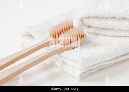 Brosses à dents en bambou à soies végétales sur une serviette blanche, brosse à dents bio biodégradable Banque D'Images