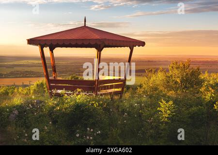 Pavillon extérieur en bois sur l'été coucher de soleil paysage fond, vallée verte, nord de la Bulgarie Banque D'Images