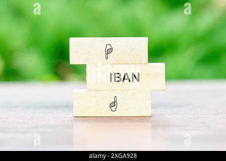 IBAN International Bank Account Number SWIFT concept. IBAN sur des blocs de bois sur une table sur un fond de plantes vertes hors de propos Banque D'Images