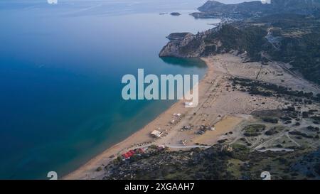 Vue aérienne d'un paysage de plage de sable isolé avec de l'eau bleue claire et quelques cabanes, plage de Tsambika, Tsambika, Rhodes, Dodécanèse, îles grecques Banque D'Images