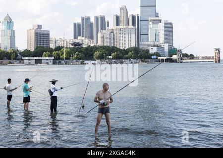 Wuhan, Chine. 07 juillet 2024. Les gens ont vu pêcher dans le parc inondé de Hankou Riverbank du fleuve Yangtze. Les niveaux d'eau dans les tronçons moyen et inférieur du fleuve Yangtsé -- le plus long fleuve de Chine -- sous l'estuaire du lac Dongting, ont dépassé le seuil d'avertissement, selon le ministère des ressources en eau. Crédit : SOPA images Limited/Alamy Live News Banque D'Images