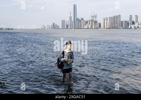 Wuhan, Chine. 07 juillet 2024. Un homme marche à travers le parc inondé de Hankou Riverbank du fleuve Yangtze. Les niveaux d'eau dans les tronçons moyen et inférieur du fleuve Yangtsé -- le plus long fleuve de Chine -- sous l'estuaire du lac Dongting, ont dépassé le seuil d'avertissement, selon le ministère des ressources en eau. Crédit : SOPA images Limited/Alamy Live News Banque D'Images