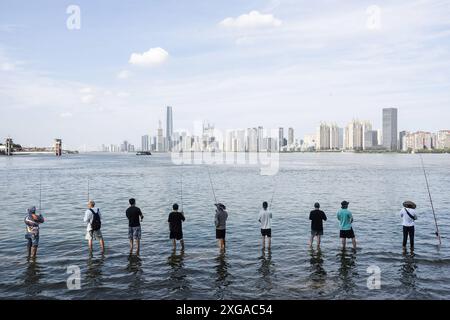 Wuhan, Chine. 07 juillet 2024. Les gens ont vu pêcher dans le parc inondé de Hankou Riverbank du fleuve Yangtze. Les niveaux d'eau dans les tronçons moyen et inférieur du fleuve Yangtsé -- le plus long fleuve de Chine -- sous l'estuaire du lac Dongting, ont dépassé le seuil d'avertissement, selon le ministère des ressources en eau. Crédit : SOPA images Limited/Alamy Live News Banque D'Images